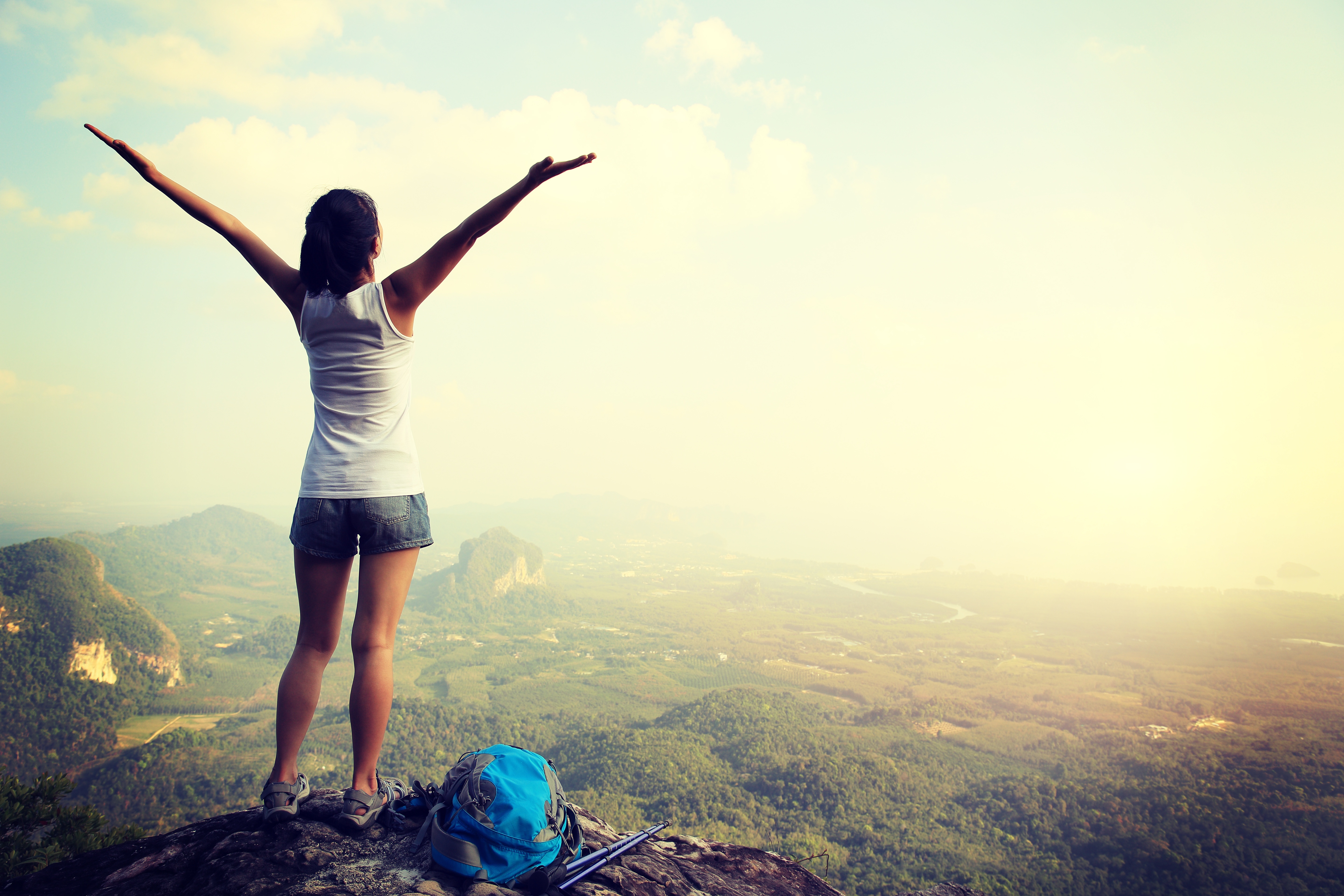 50078668_xxl cheering woman hiker open arms at mountain peak.jpg